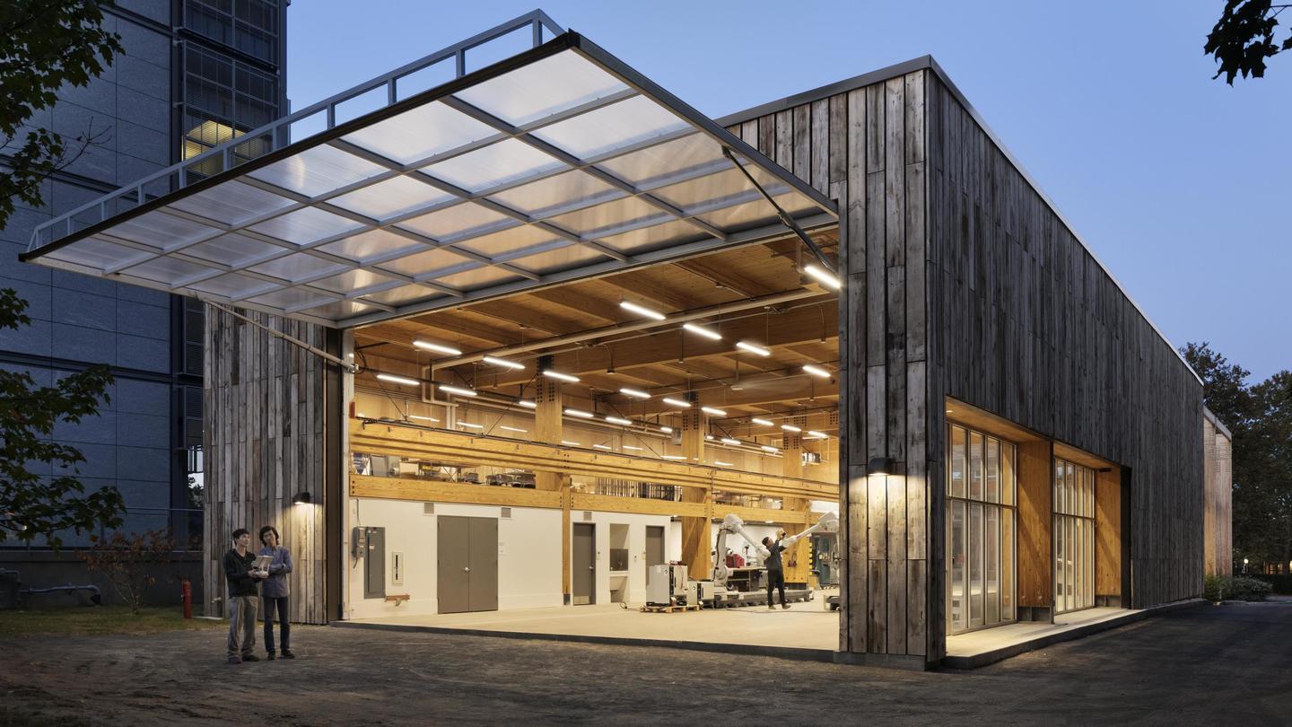 Exterior of a barn like building showing a large garage door open allowing users to view the interior of the space